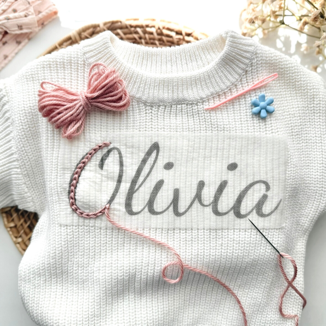 White Knit Baby Sweater with Pink Yarn Embroidery and a Stick and Stitch Name